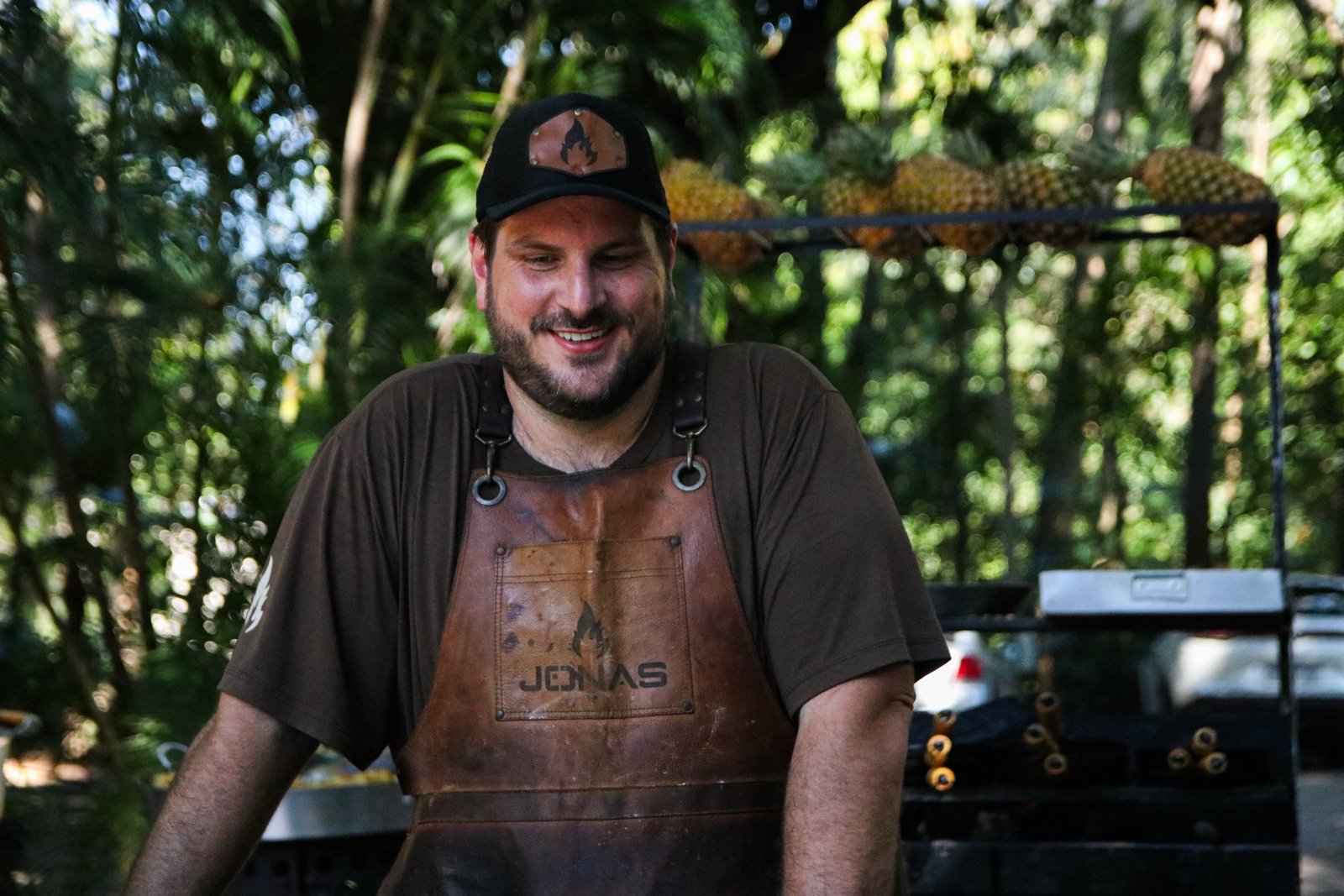 Jonas, o parrilheiro, sorrindo no comando da brasa